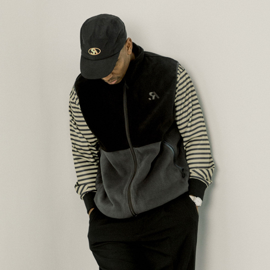 Two-tone black and gray vest with a logo on a white background