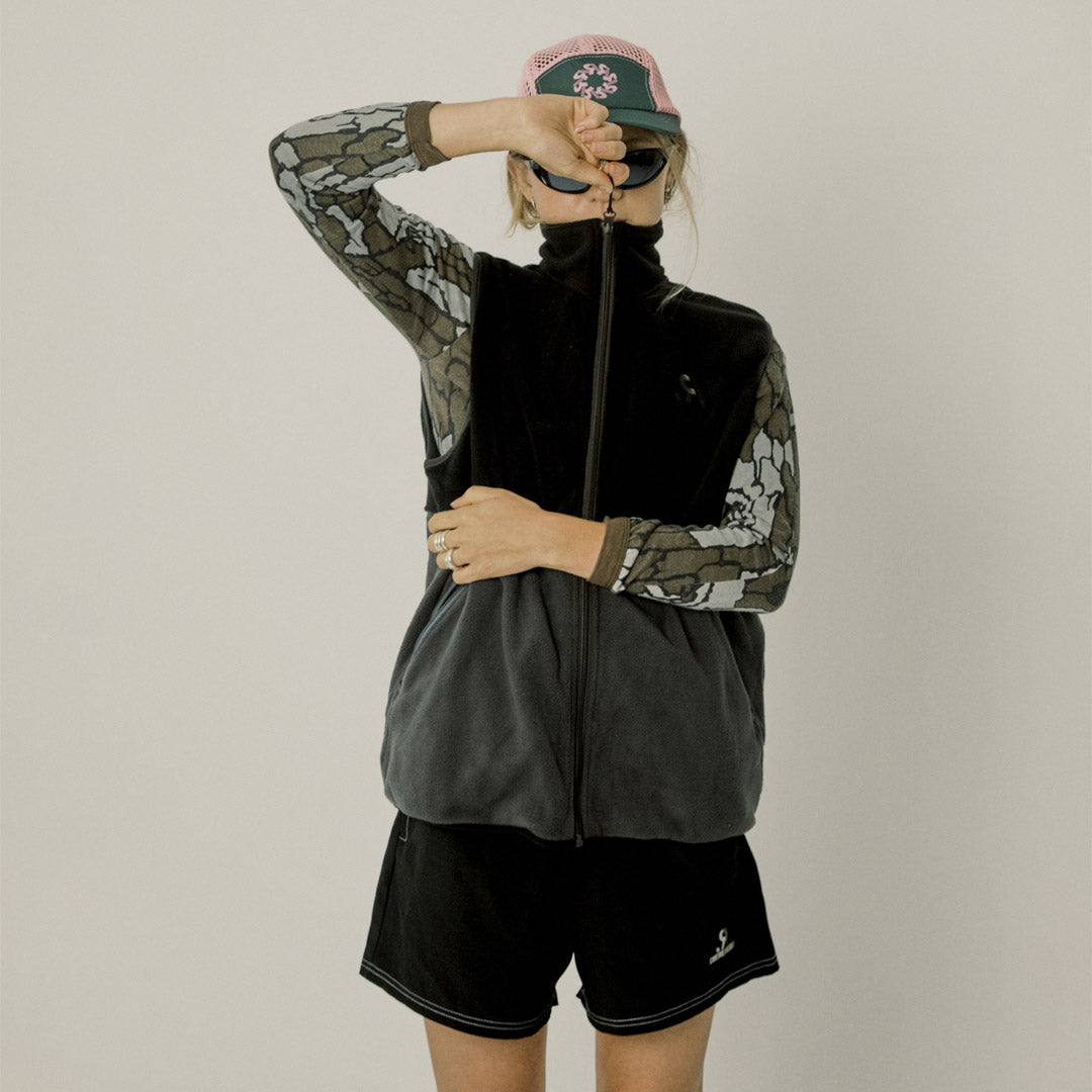 Two-tone black and gray vest with a logo on a white background