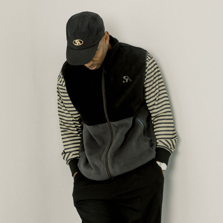 Two-tone black and gray vest with a logo on a white background