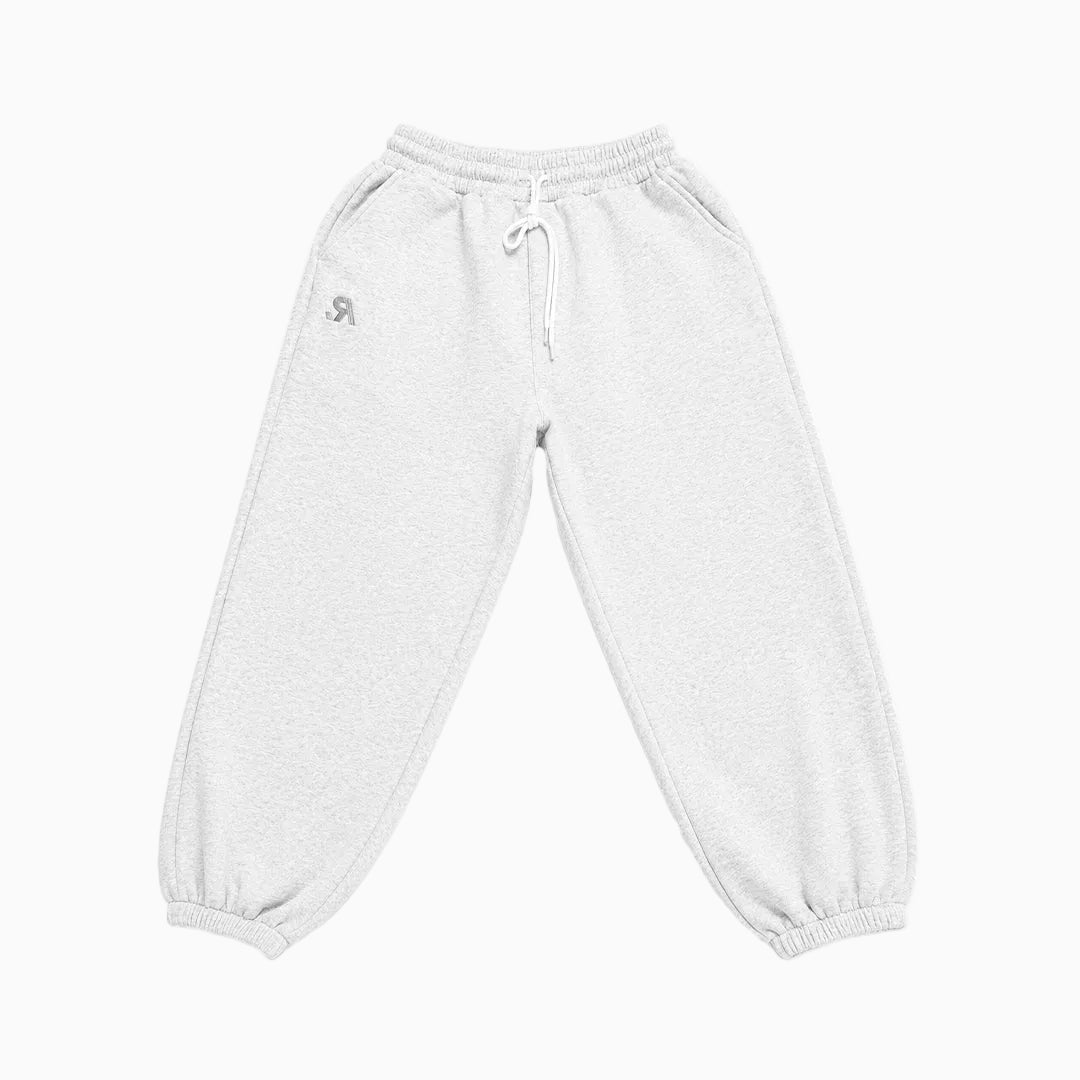 A pair of light gray heather sweatpants with an elastic waistband, white drawstring, and elastic cuffs, featuring a small gray logo on the left hip.