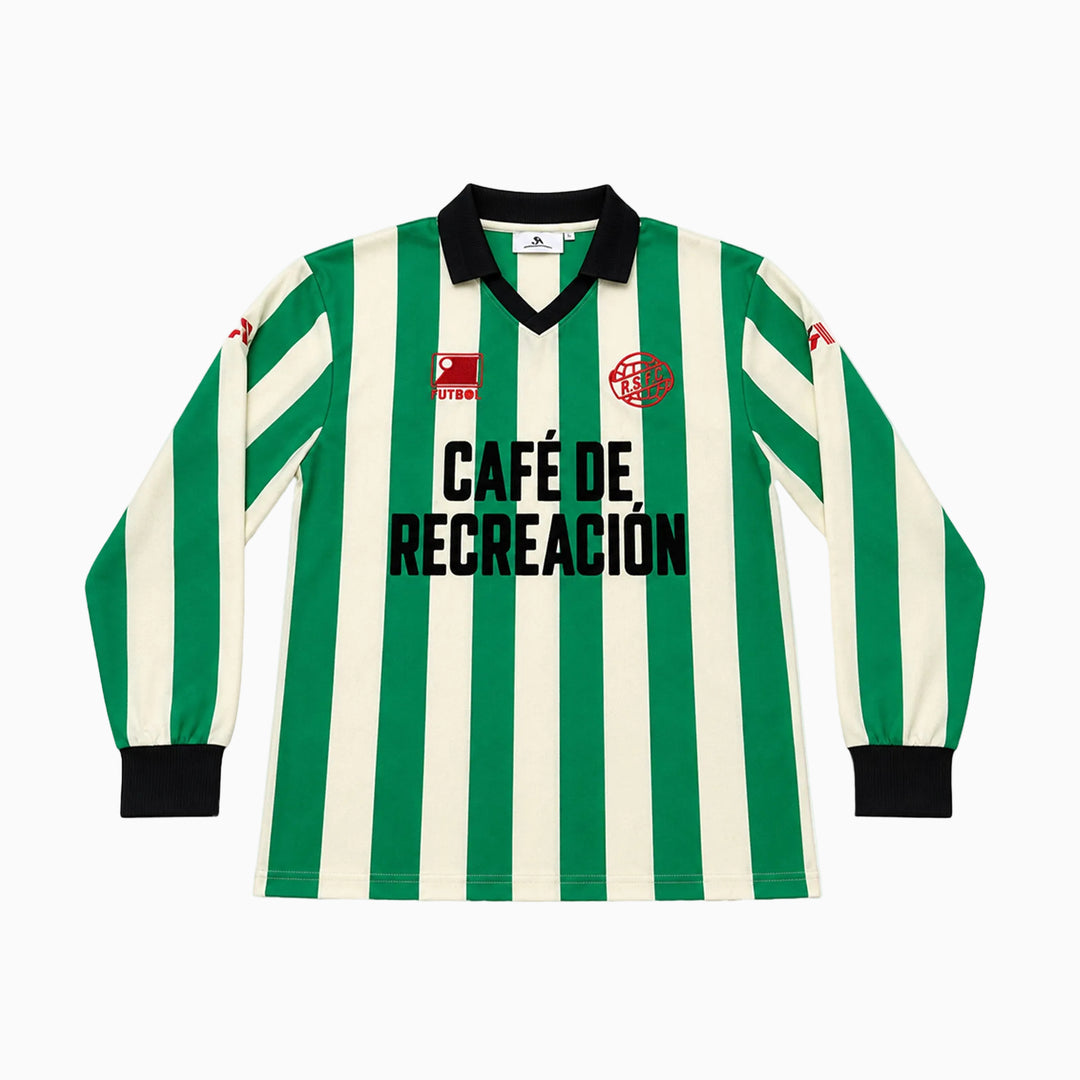 A long-sleeve striped soccer jersey with green and off-white vertical stripes, a black V-neck collar, black cuffs, and 'CAFÉ DE RECREACIÓN' printed in black across the chest. The jersey features the Real Betis club crest on the left chest and a sponsor logo on the right chest.