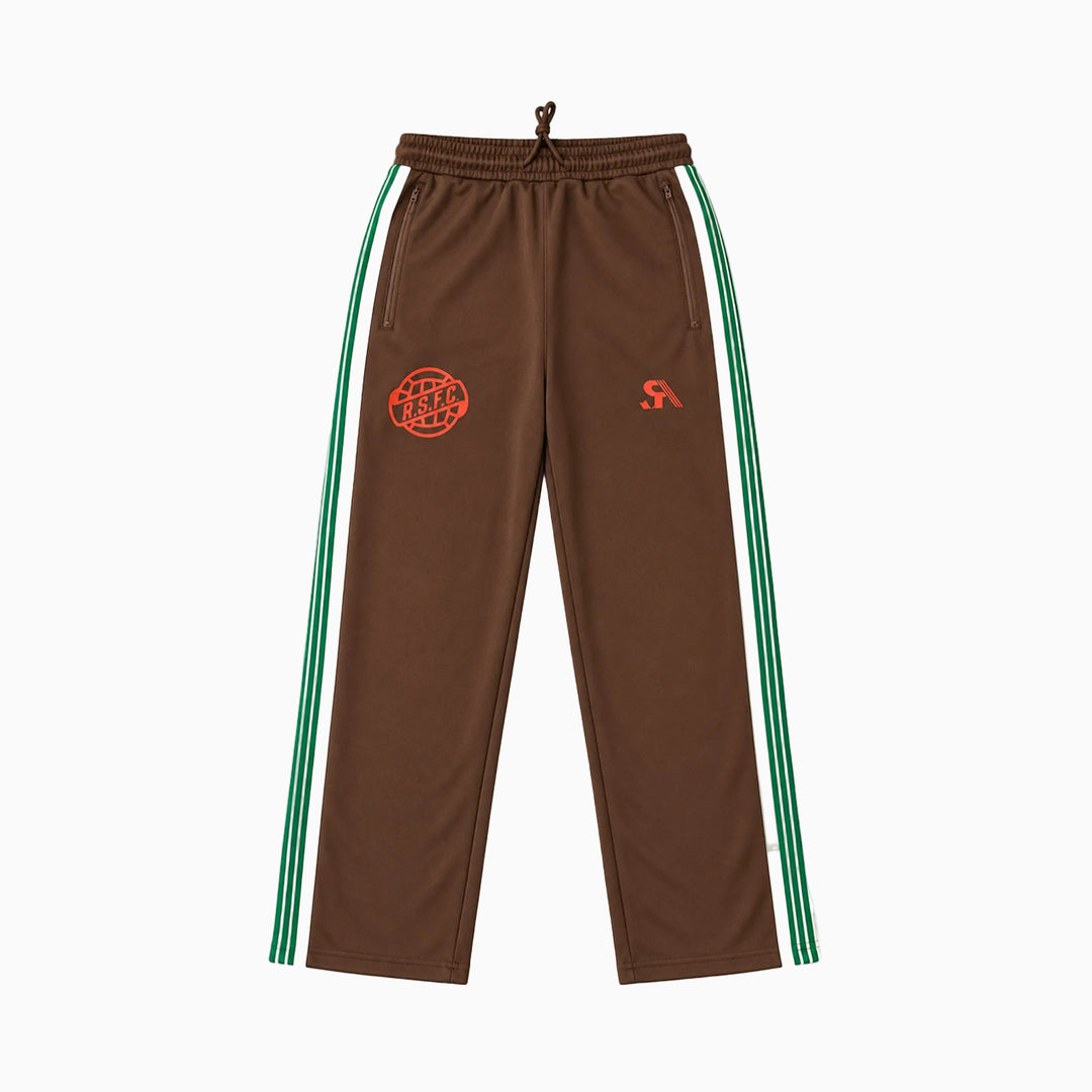 Brown track pants with green and white side stripes, featuring a red circular 'Street Style' logo on the left thigh and a red 'RS' logo on the right thigh, shown against a plain white background.